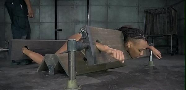 Bound ebony sub in pillory gets spanked
